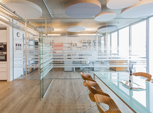 Office with sound absorbers Round sound absorbers on the ceiling of an office improve the room acoustics.