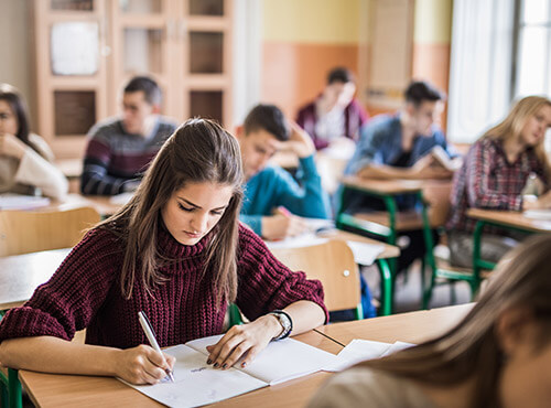 Sound insulation in schools helps leaning and concentration when working. A girl concentrates on her work in the classroom at school with sound insulation and noise insulation.